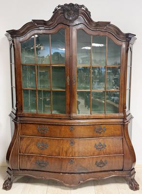 an antique wooden china cabinet with glass doors and drawers