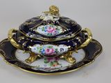 a black and gold plate with a bowl on it