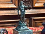une statue représentant un homme tenant un poisson sur une table