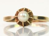 une image représentant une bague en or avec une perle au centre
