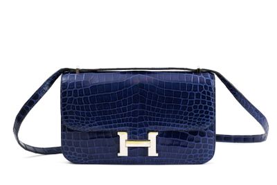 a blue handbag with a gold h logo on the front