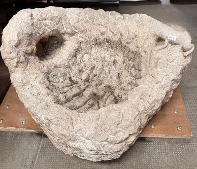 a large stone bowl sitting on top of a piece of wood