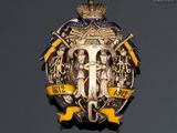 a badge on the wall of a building with a crown on top of it