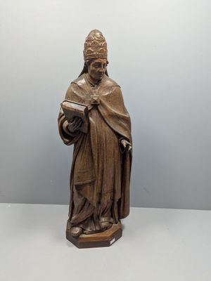 statue en bois représentant un homme tenant un livre et vêtu d'une robe