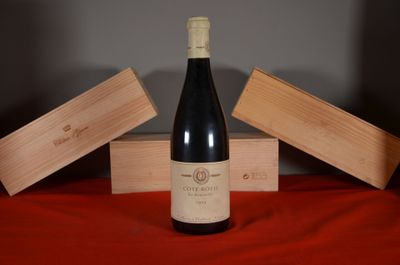 a bottle of wine sitting on a table next to two wooden boxes
