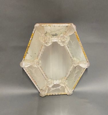 a glass vase that has a yellow and white design on it