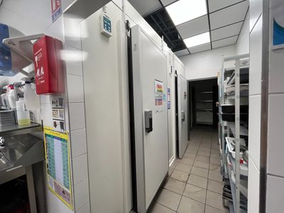 many refrigerators in this kitchen that are lined up