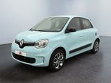 La voiture bleu clair est garée dans une pièce au sol noir.