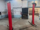 deux ascenseurs rouges dans un garage doté d'une verrière