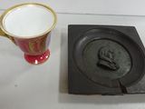 a cup and a plate on a table next to each other