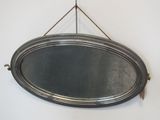 un miroir ovale argenté accroché au mur
