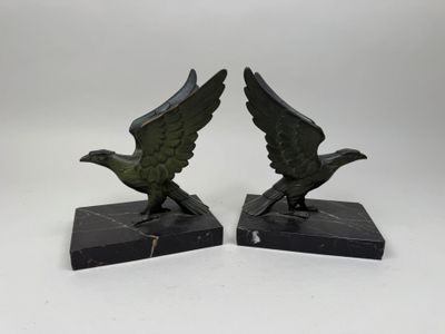 une paire de serre-livres en bronze représentant des aigles, posés sur des socles en marbre