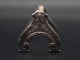 a close up of a silver ring on a black surface