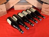 several bottles of wine are lined up on a red table