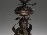 bronze statue of a bird on top of a fountain with a hat on it ' s head
