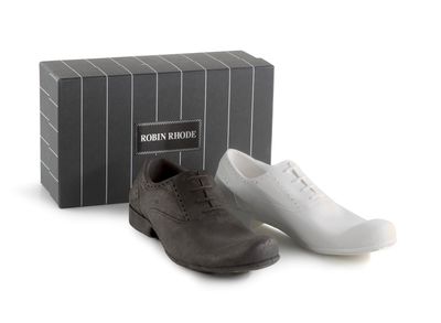 two pairs of men ' s shoes sitting next to a box of shoes