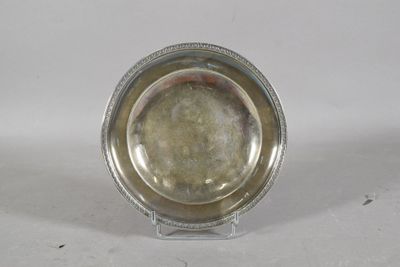 a silver plate on a clear stand on a white surface