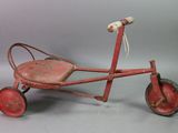 an old fashioned red tricycle with a wooden seat and wheels