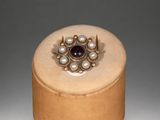 gold ring with amethorate and pearls on a wooden box