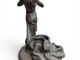 statue of a woman standing on a rock with her hands in the air