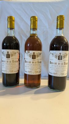 trois bouteilles de vin posées sur une table, l'une à côté de l'autre