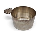 a small metal bowl with a leaf decoration on it