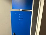 un casier bleu dans un coin des toilettes