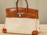 a brown and white purse sitting on top of a wooden table