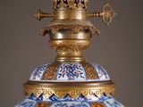 a large blue and white vase with a gold top