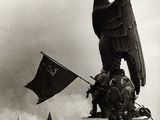 photo en noir et blanc d'une statue d'aigle au sommet d'un immeuble