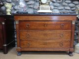 une commode en bois surmontée d'une horloge