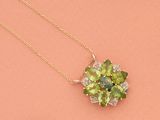 un gros plan d'un collier orné d'une fleur verte sur fond rose