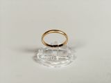 an image of a gold wedding ring on a clear stand