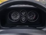 a close up of a dashboard with gauges and a steering wheel