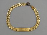 un gros plan d'un bracelet en or orné d'une plaque portant un nom