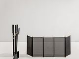 Le pare-feu noir et doré se trouve à côté d'une cheminée noire et blanche