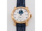 a close up of a gold wrist watch with a blue strap