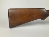 a wooden rifle on a clear acrylic display stand