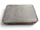 an old black suitcase sitting on top of a white surface