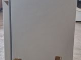 a white refrigerator sitting in the middle of a room