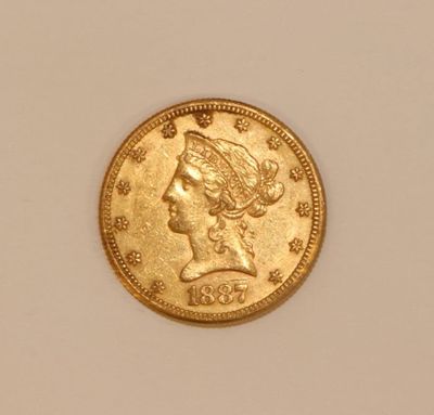 a close up of a gold coin on a white surface