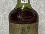 an old bottle of liquor sitting on top of a counter