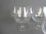quatre verres à vin vides posés les uns à côté des autres sur une table