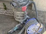 a vacuum that is sitting on the ground next to a hose