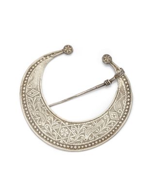 une broche en argent en forme de croissant, au motif très travaillé