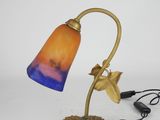 brass table lamp with a blue and orange glass shade and a starburst on the base