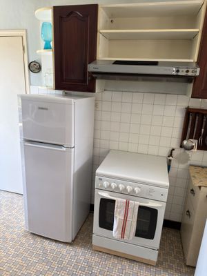 a small kitchen with a refrigerator, stove, and refrigerator freezer
