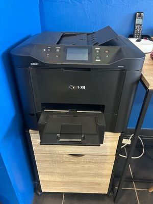 the printer is sitting on top of the cabinet in the room