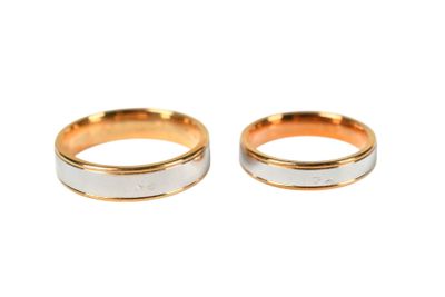 two gold and silver wedding rings on a white background