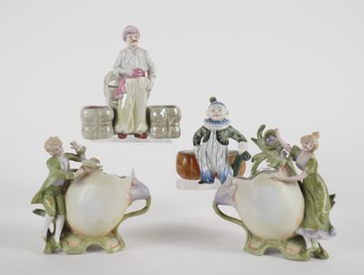 three figurines of people sitting on top of a white table